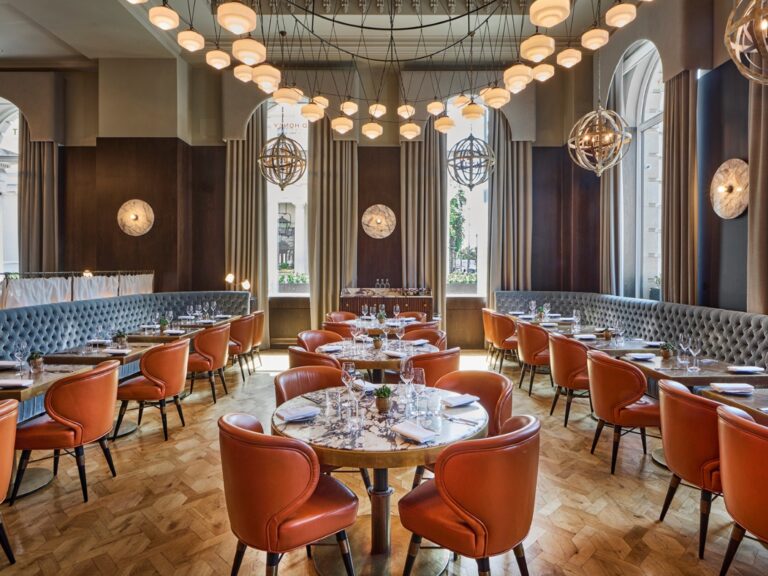 Wild Honey St James dining room, with arched windows and leather chairs under a lattice of pendant lights, Sofitel London St James