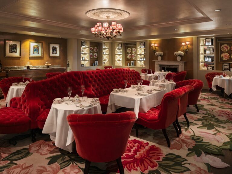 The Rose Lounge, with red tufted sofas and a floral carpet, laid for afternoon tea, Sofitel London St James