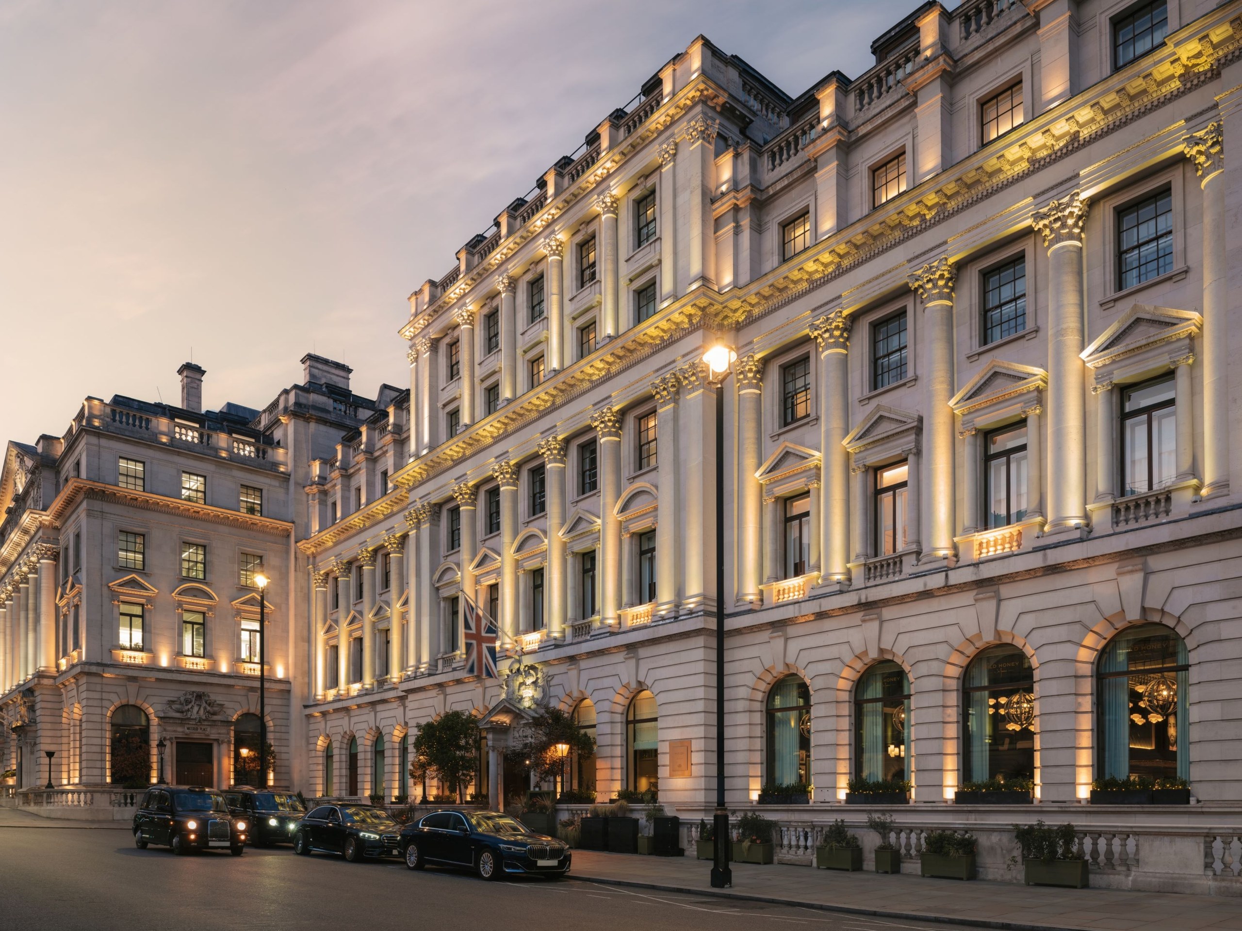 The hotel corner on Pall Mall at dusk, with cars waiting at the kerb, Sofitel London St James