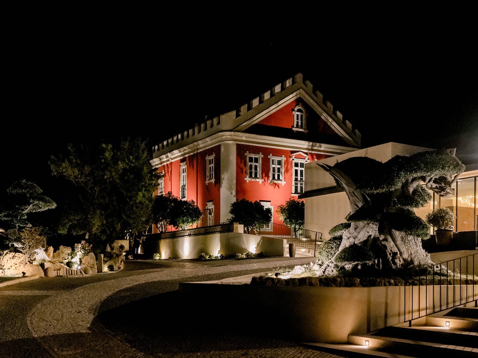 The Palace lit at night, with a sculpted tree in the foreground, Solar do Paço Algarve