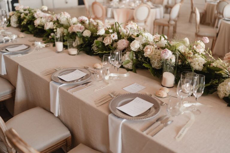 A banquet table with a long garland of white and pink flowers, menus and candles, Solar do Paço Algarve