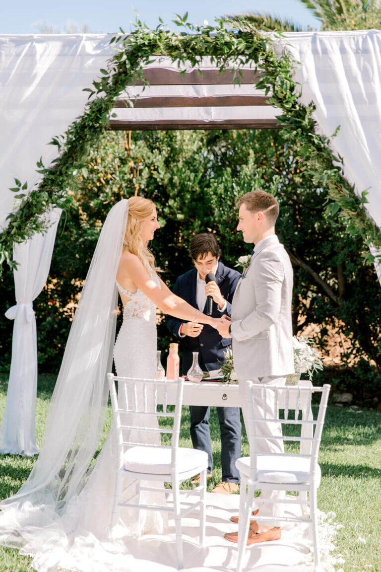 Vows under a green and white draped garden arch, Sonho a Dois Algarve Wedding Planners