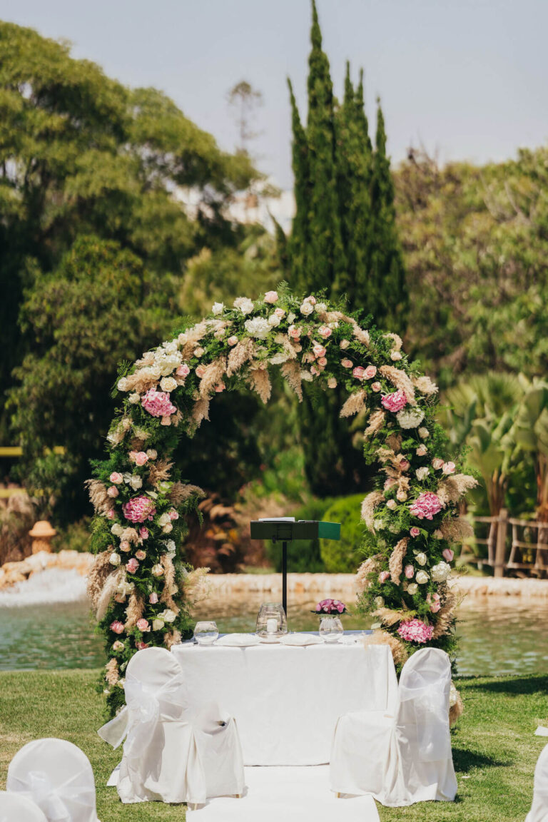 Ceremony table and floral arch set in a garden, Sonho a Dois Algarve Wedding Planners