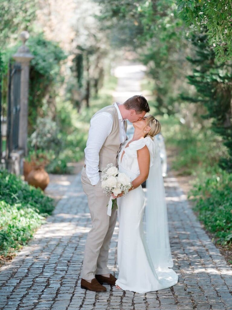 Couple kissing on a cobbled path lined with trees, Sonho a Dois Algarve Wedding Planners