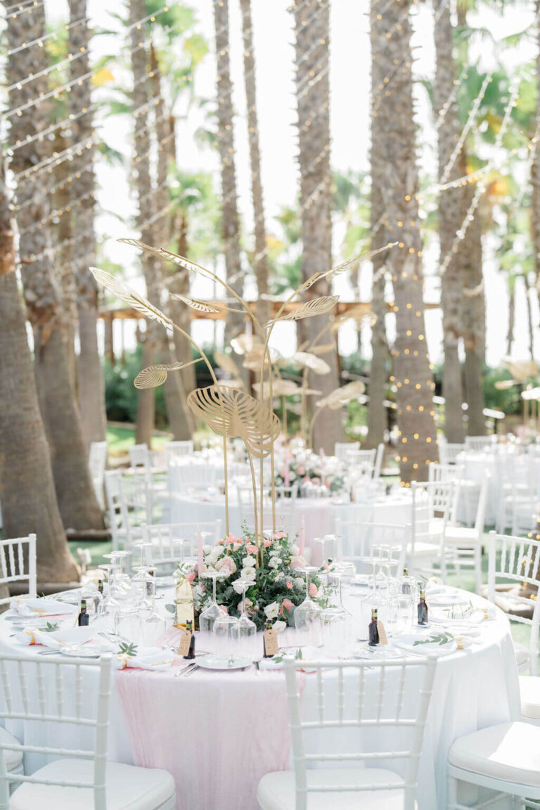 Round tables with pink candles and florals among tall palms, Sonho a Dois Algarve Wedding Planners