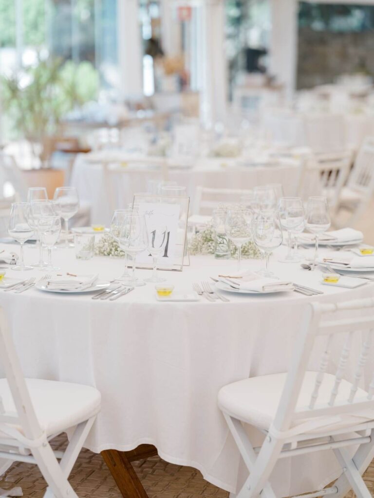 Round tables set with white linen and place cards, Sonho a Dois Algarve Wedding Planners