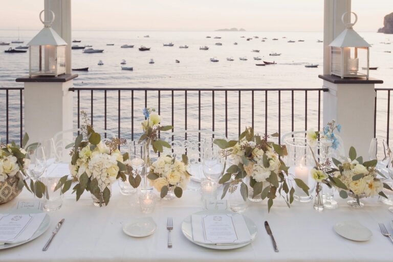White flowers, lanterns and place settings above the bay at Rada, Positano, Sophisticated Weddings