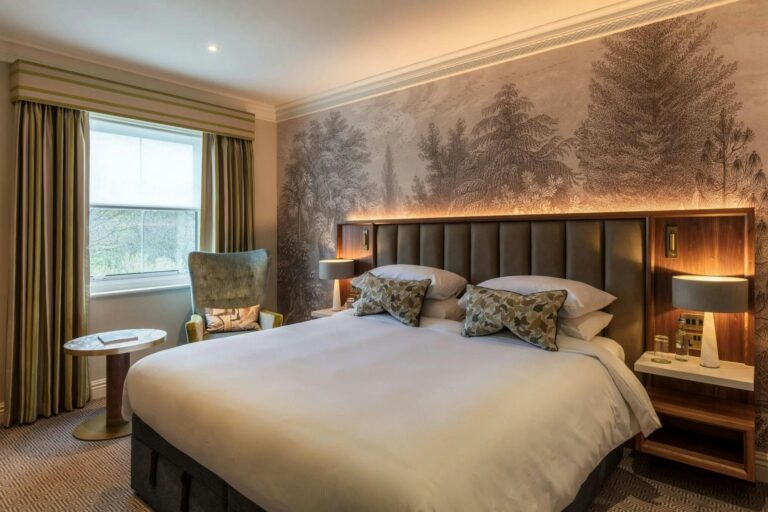 A bedroom with a double bed and woodland wall mural, Sopwell House