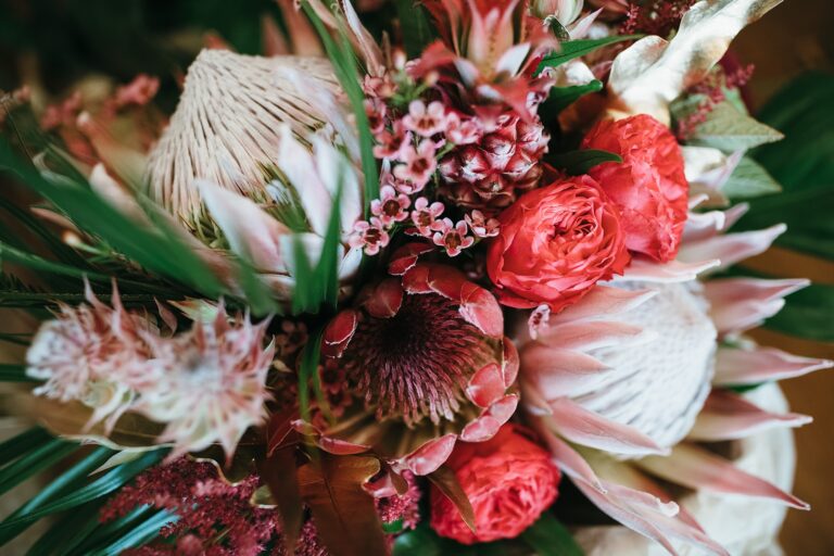 A statement bouquet of coral protea and burgundy rose, Sorcha Herbert Flowers