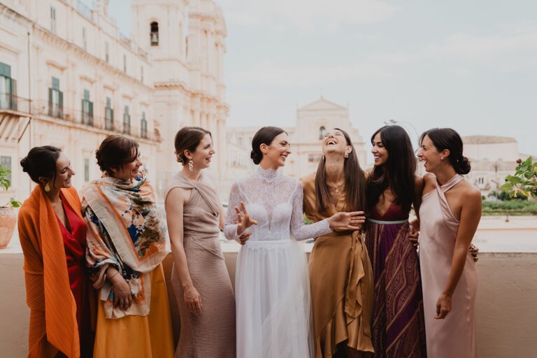 The bride and her five friends laughing together in the piazza before Noto's Baroque cathedral, Sparx Wedding & Event Planner