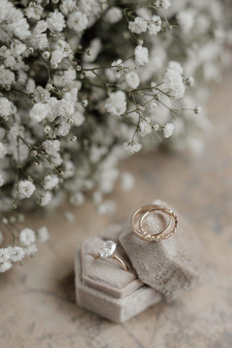 Wedding and engagement rings resting in a velvet box beside a spray of gypsophila, Sparx Wedding & Event Planner