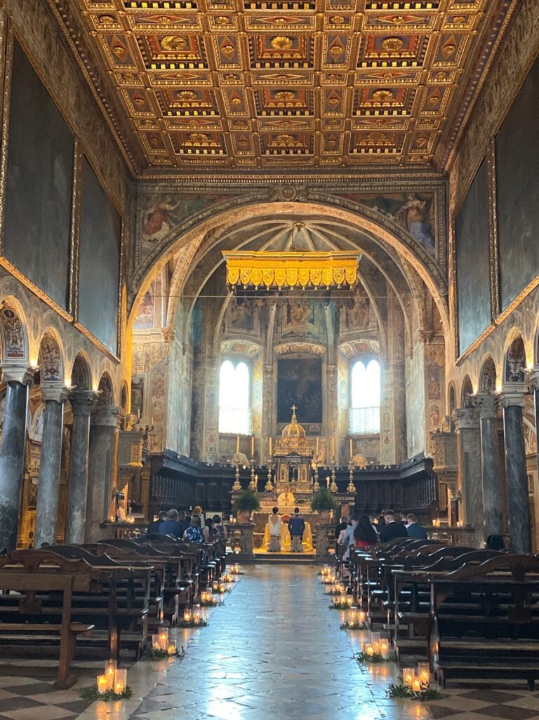 A basilica with a gilded coffered ceiling, candles the length of the aisle, Sposa Mediterranea By A&C