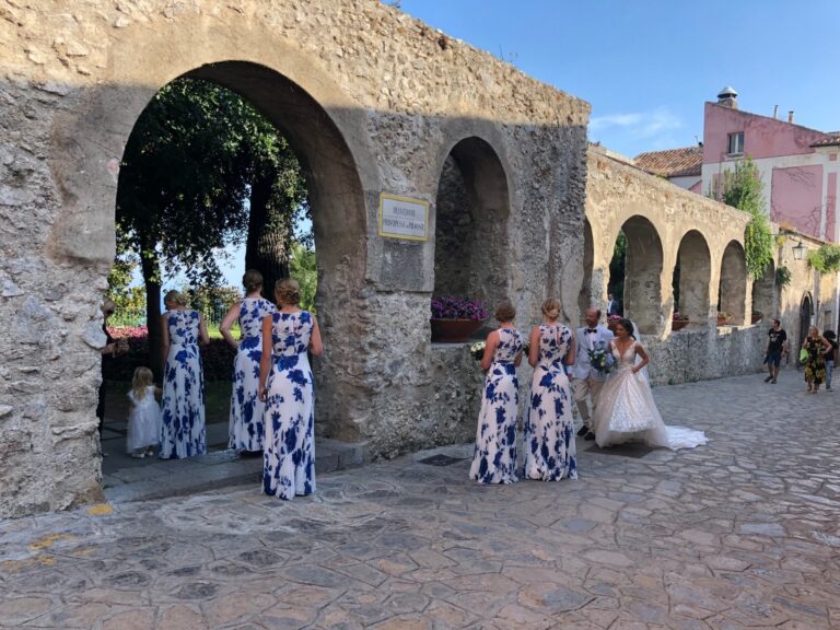 Bridesmaids in blue and white waiting under a stone arcade, Sposa Mediterranea By A&C