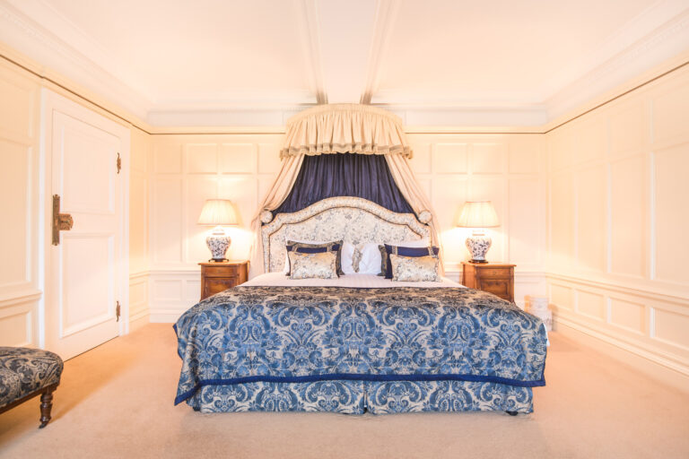 Room 8, a panelled bedroom with a canopied bed and blue damask bedspread, Springkell