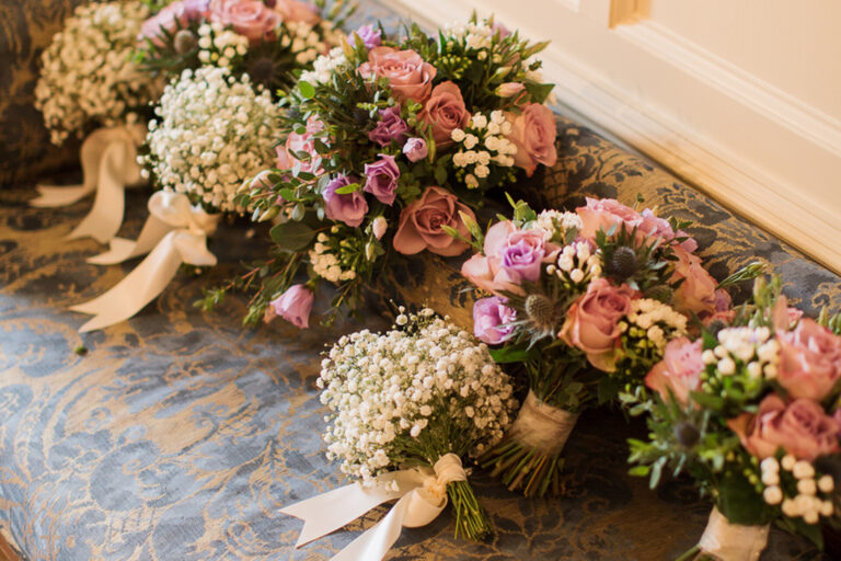 Bridal and bridesmaid bouquets of roses and gypsophila laid on a damask cloth, Springkell