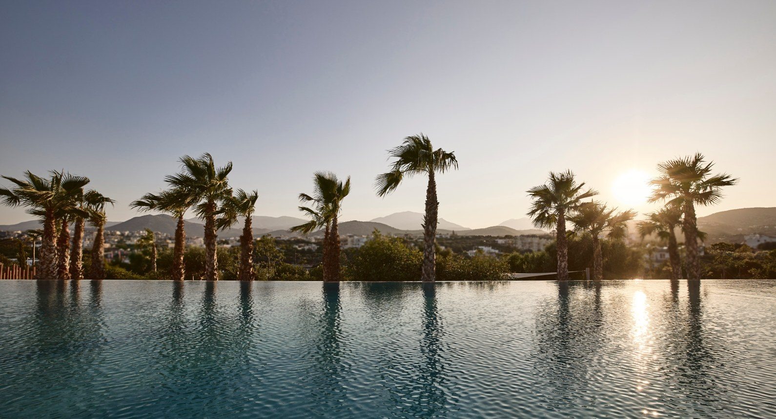 Palm trees beside the 25-metre pool at sunset, St Nicolas Bay Resort Hotel and Villas