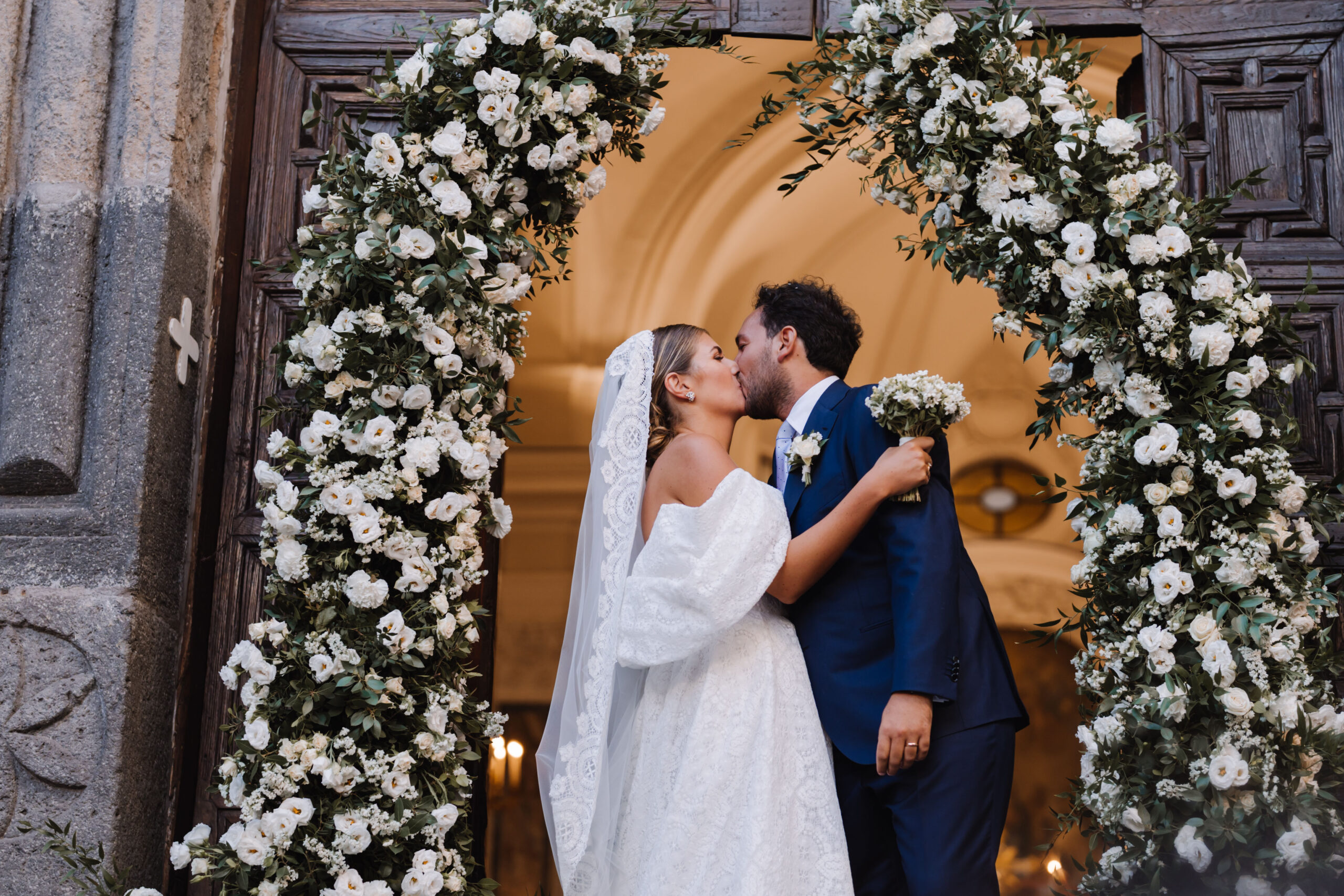White floral arch at the church door after Jolanda and Danilo's ceremony in Ischia's historic centre, Stefania Silvestro