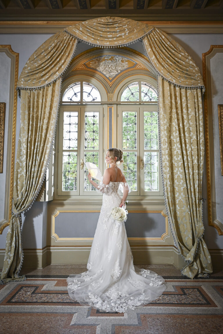 The bride in a gilded salon, framed by a curtained window, Stefano Lunardi