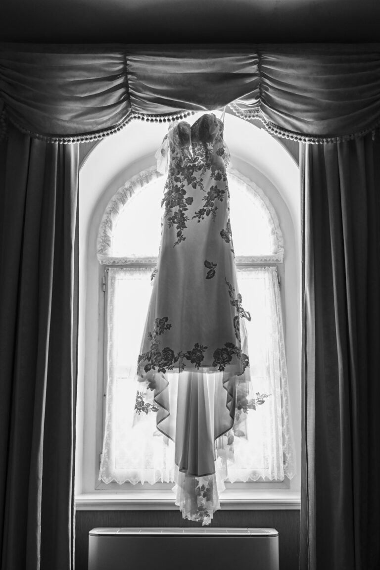 The wedding dress hanging in a tall arched window, in black and white, Stefano Lunardi