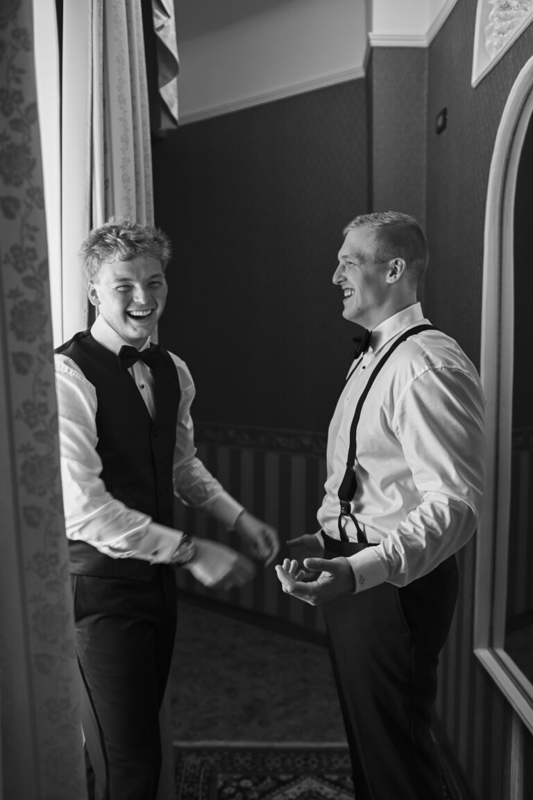 The groom and a friend sharing a laugh while getting ready, in black and white, Stefano Lunardi