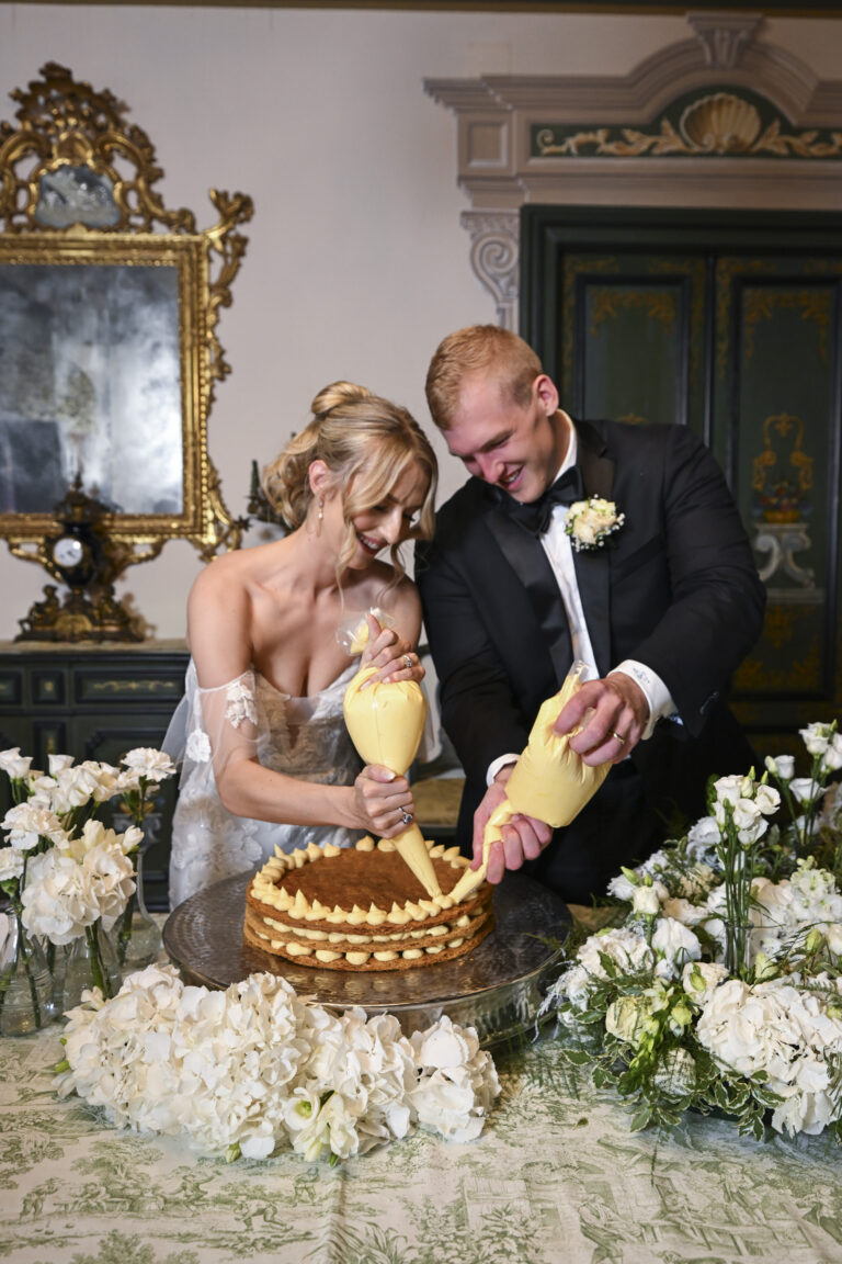The couple piping cream onto their cake at the reception, Stefano Lunardi