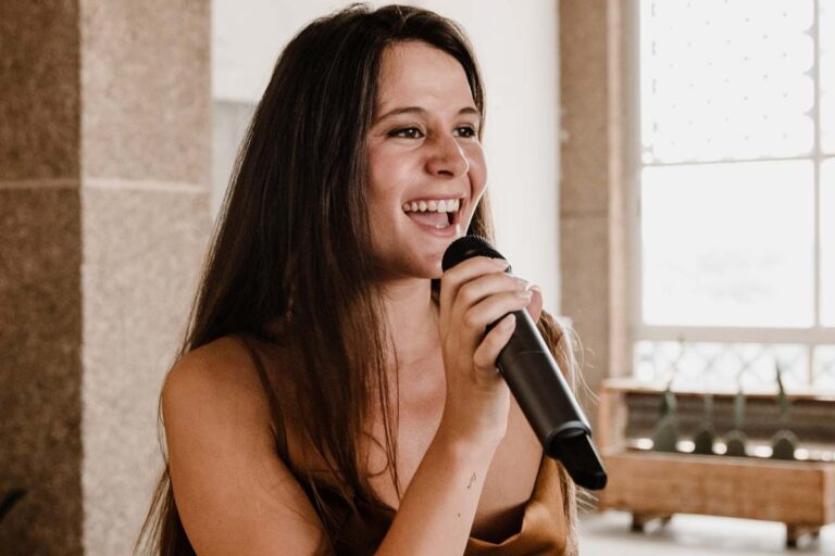 The lead vocalist singing into a microphone beside tall windows, Stereo Star Band