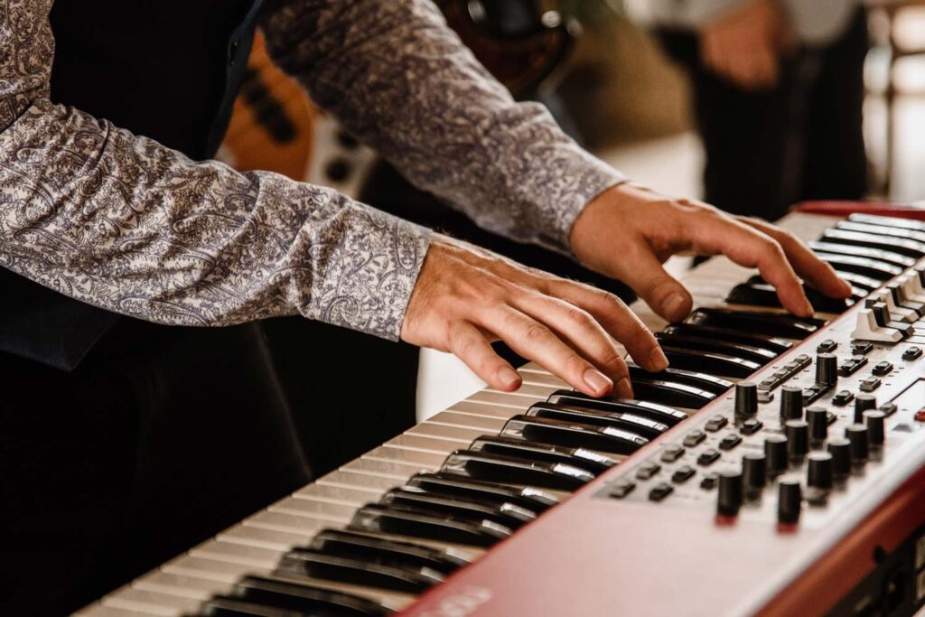 Hands playing a red stage piano, Stereo Star Band