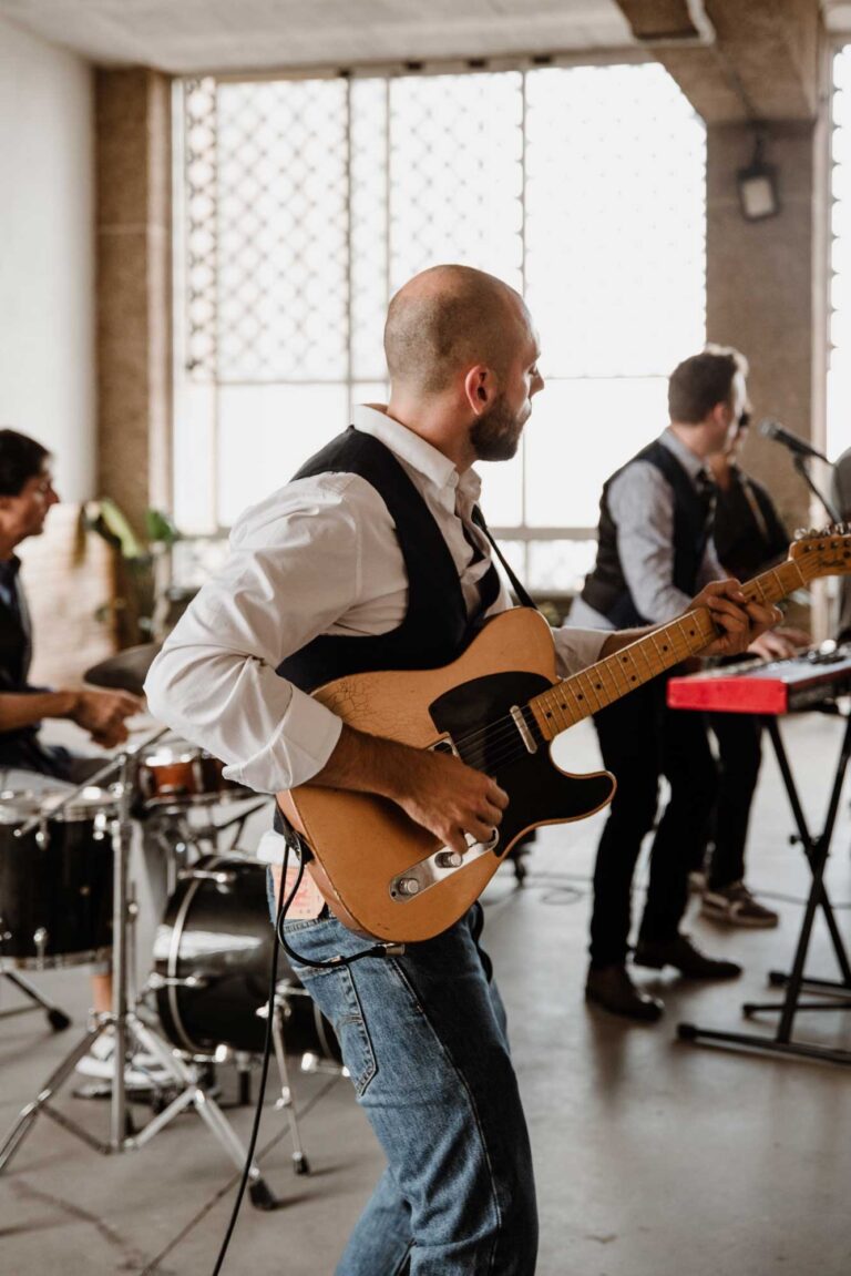 A guitarist in a waistcoat playing a tan electric guitar, Stereo Star Band