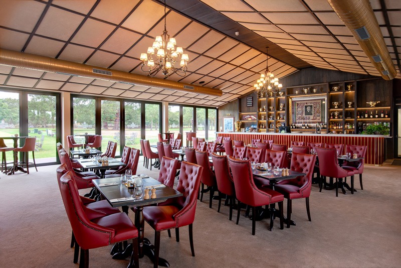 Dining room with red leather chairs and garden views, Stoke Park