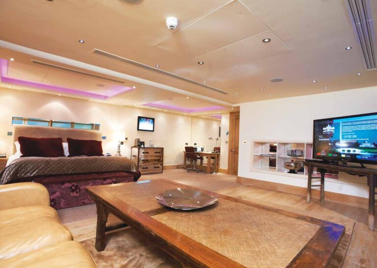 A suite bedroom and lounge with a wall mounted television, Stoke Park