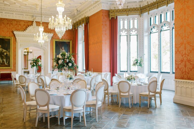 The Waldegrave Suite laid for a wedding breakfast, round tables and chandeliers beneath tall Gothic windows, Strawberry Hill House