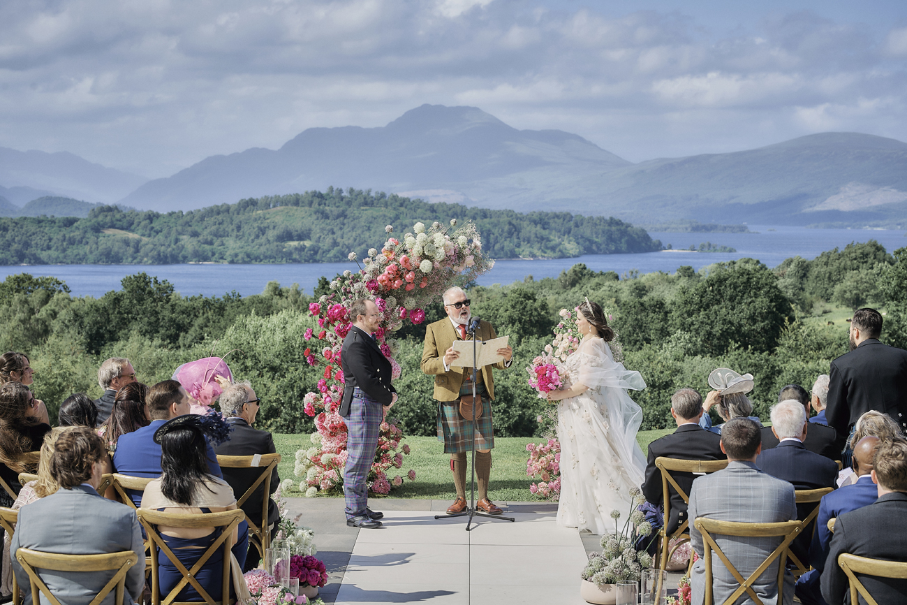 An outdoor ceremony at Boturich Castle, Loch Lomond and the hills behind, Stuart Wood Photography