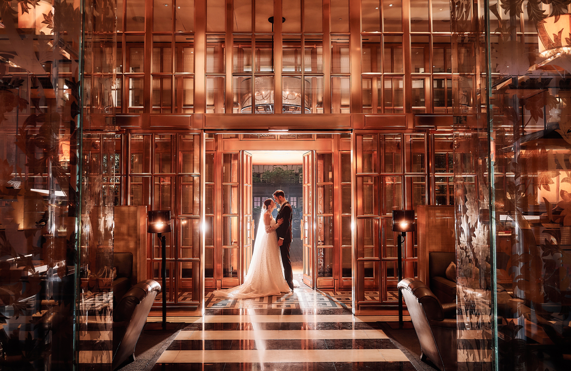 A bride and groom framed in a glowing doorway at Rosewood London, Stuart Wood Photography