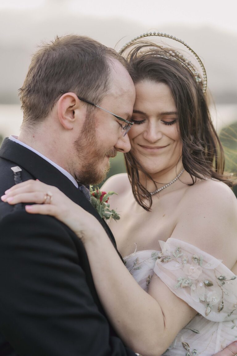 A bride and groom in a close embrace above Loch Lomond, Stuart Wood Photography