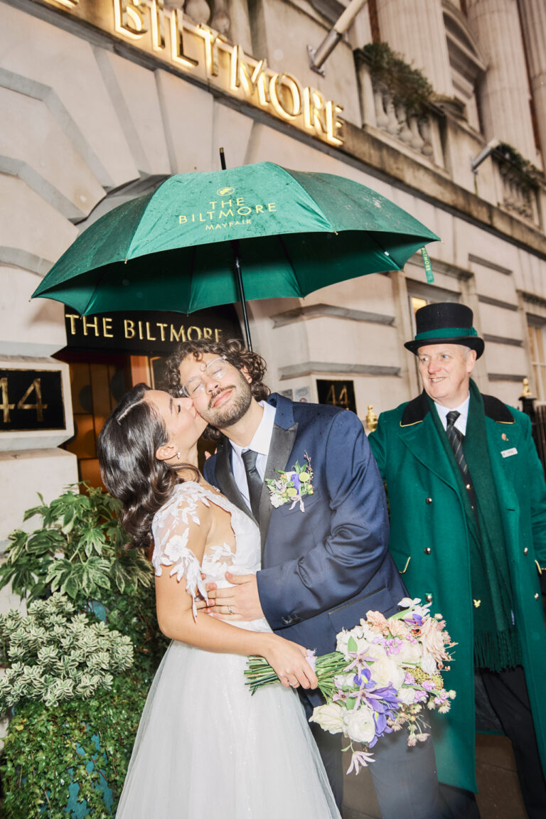 A kiss under the hotel umbrella outside The Biltmore, Mayfair, Stuart Wood Photography