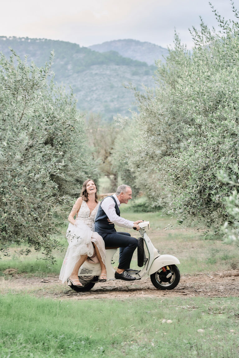 A bride and groom on a Vespa in an olive grove at Sa Casa Bona, Mallorca, Stuart Wood Photography
