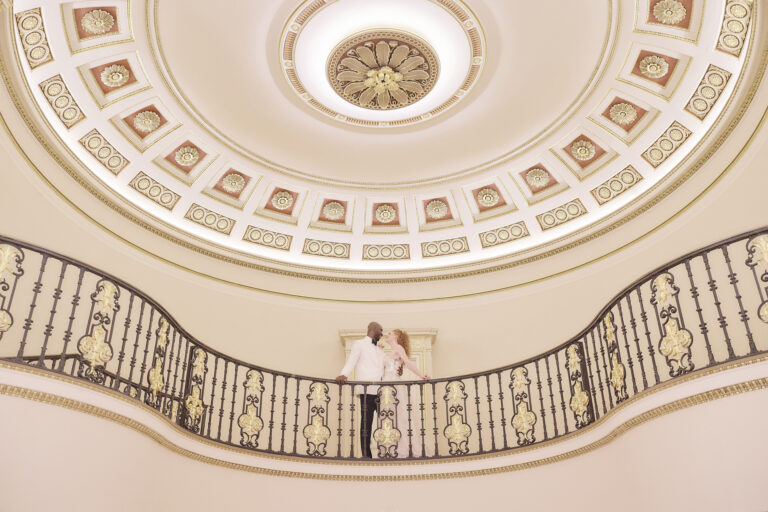 A couple on the balcony beneath the domed ceiling of The Lansdowne Club, Mayfair, Stuart Wood Photography