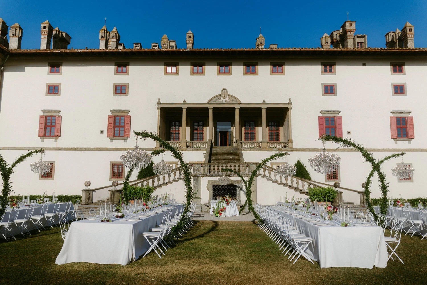 Long dinner tables set on the lawn before the Renaissance villa at Tenuta di Artimino, near Florence, Studio Fotografico Bacci