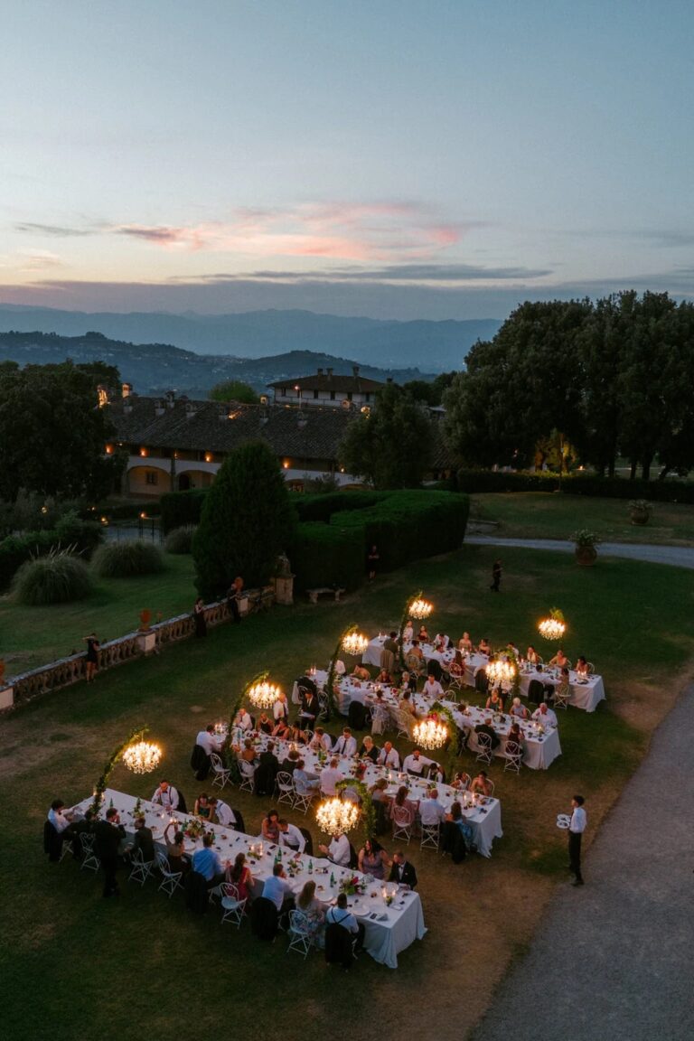 Dinner at dusk from above, chandeliers glowing over the tables in the garden at Tenuta di Artimino, Studio Fotografico Bacci