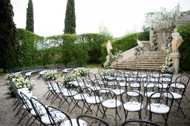 Ceremony chairs in a Renaissance garden in Verona, a statued staircase dressed in white flowers and wisteria, Suellen Fernandes Weddings & Celebrations