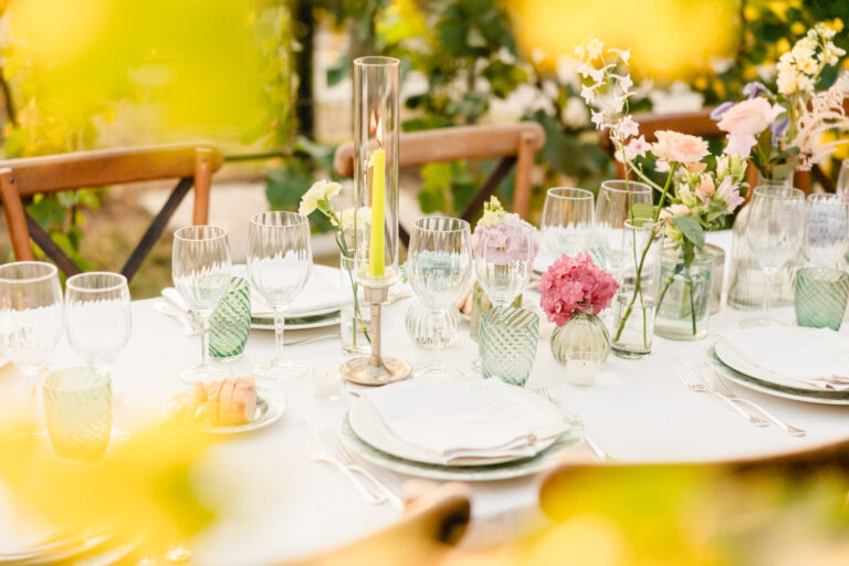 Place setting detail: green glassware and pink flowers on a white cloth, Suellen Fernandes Weddings & Celebrations