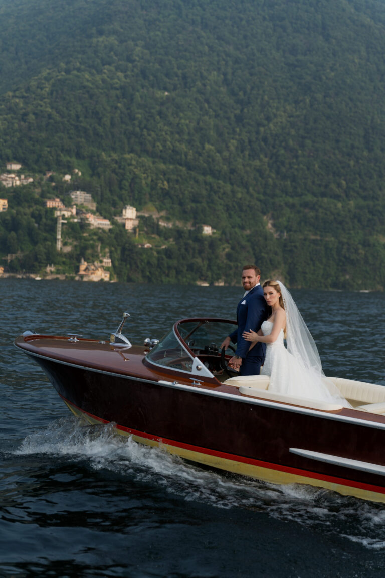 The couple crossing Lake Como in a wooden motor launch, Suellen Fernandes Weddings & Celebrations