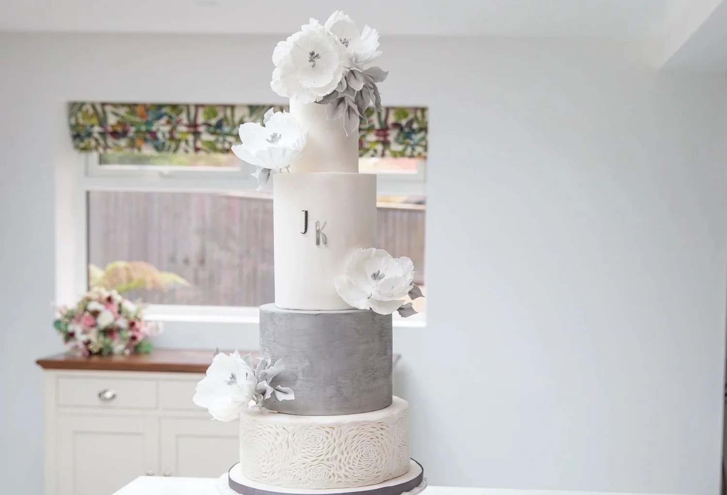 A white and grey tiered wedding cake with sugar flowers, Sugar and Spiced Cakes