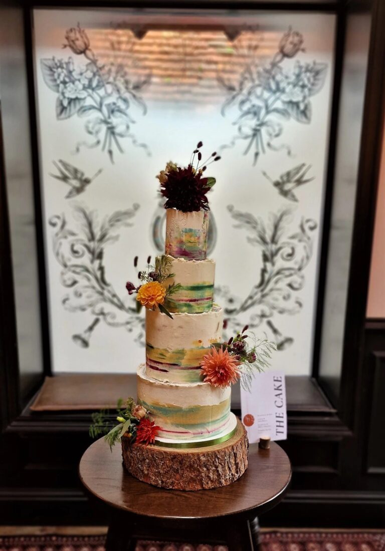 A semi-naked wedding cake with autumn flowers on a log slice, Sugar and Spiced Cakes