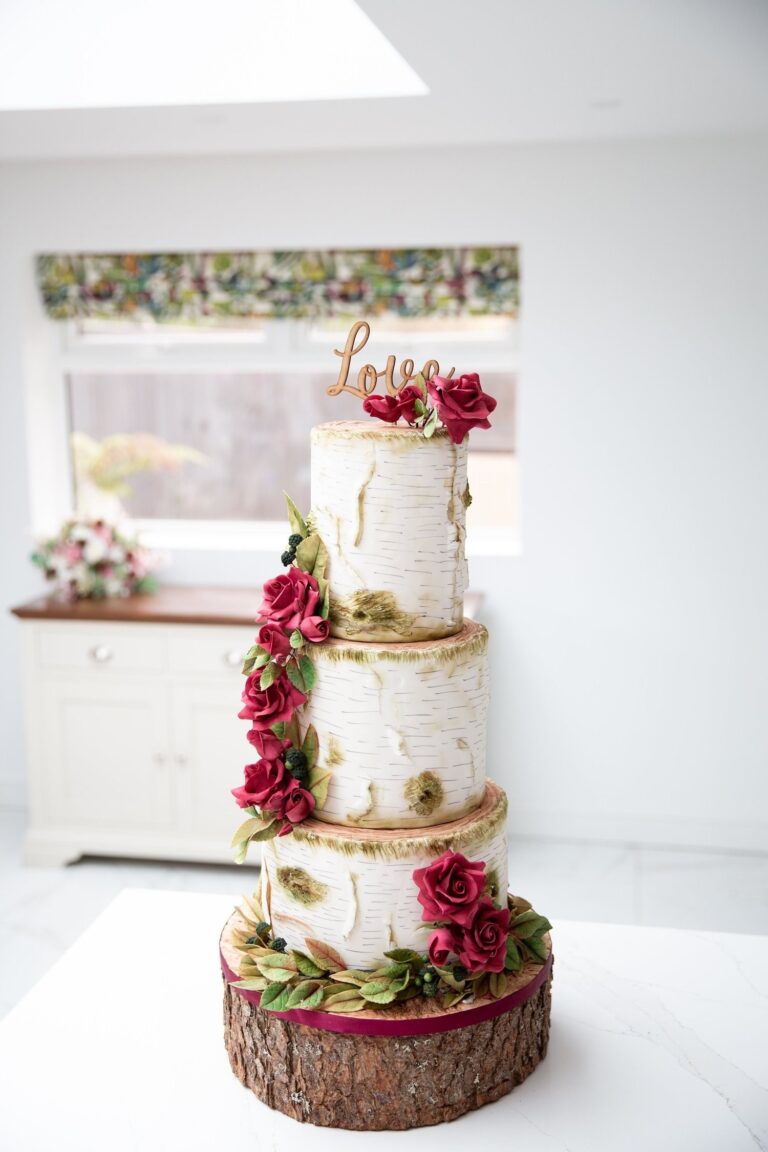 A tiered wedding cake with red sugar flowers on a log slice, Sugar and Spiced Cakes