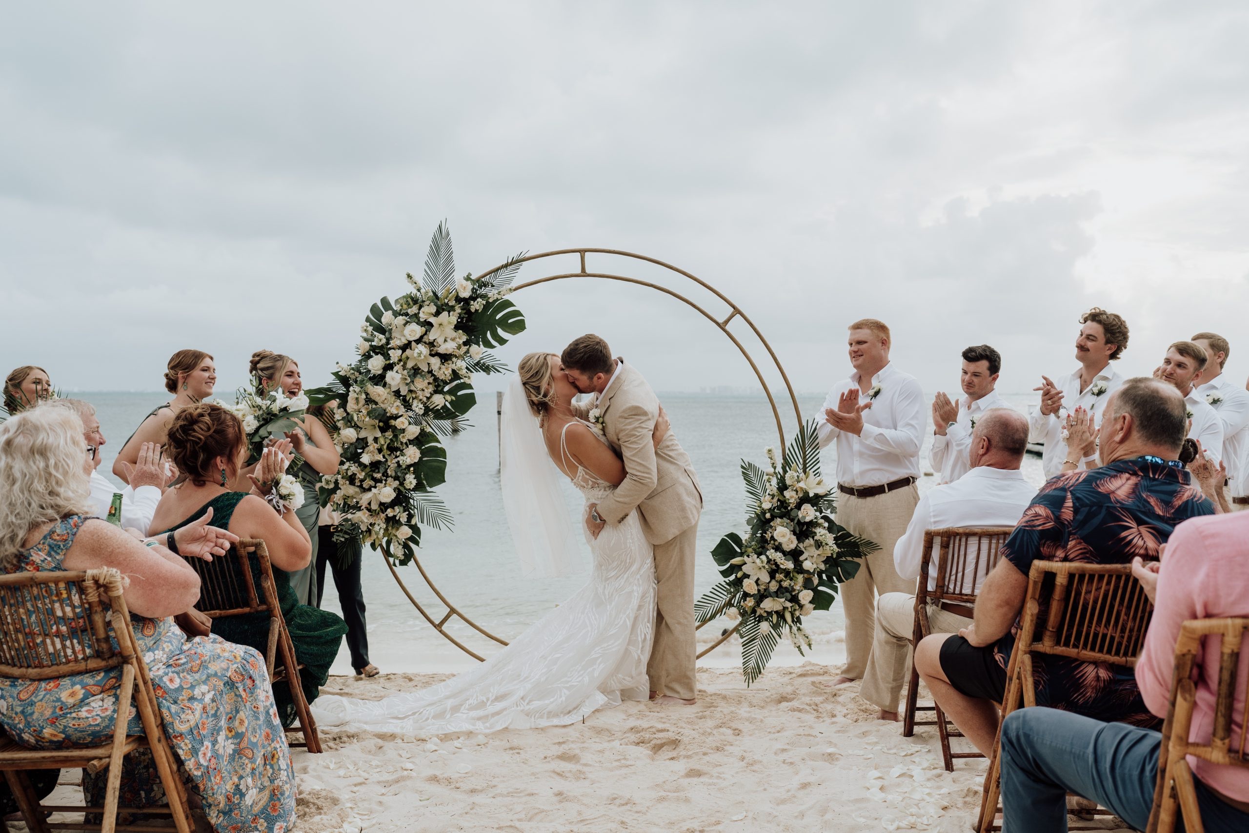 Beach ceremony in front of a floral circular arch, SunHorse Weddings