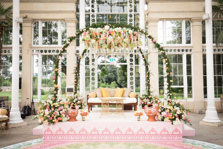 A floral mandap beneath the glazed dome of the Great Conservatory, set for a ceremony, Syon Park
