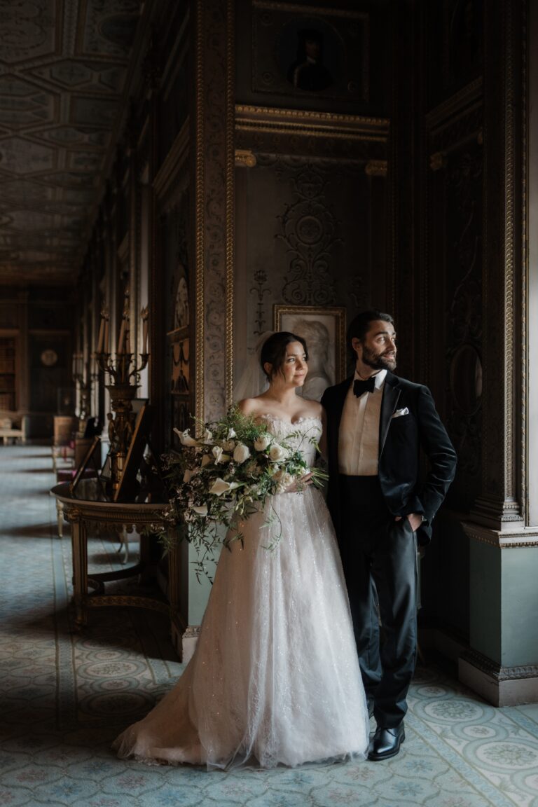A couple in the Long Gallery, the bride carrying a loose cascading bouquet, Syon Park