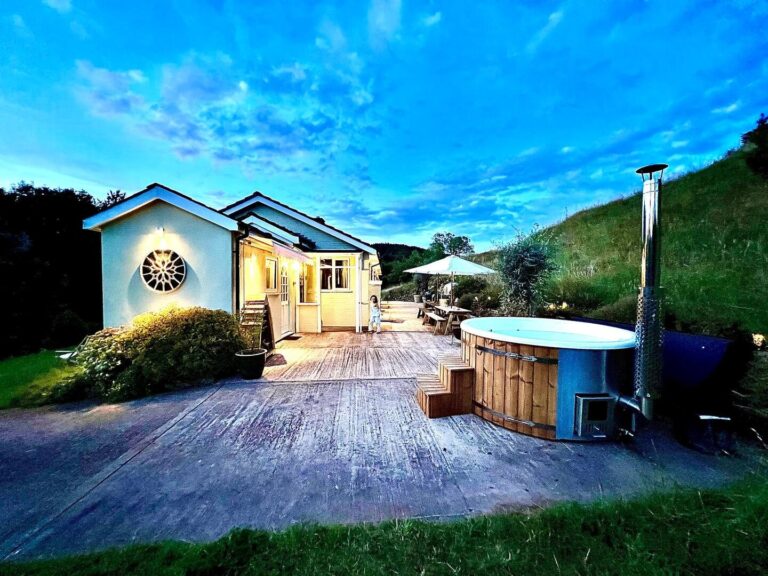 Hilly Haven at dusk, a hillside bungalow with a decked terrace and a wood-fired hot tub, Tan House Newland