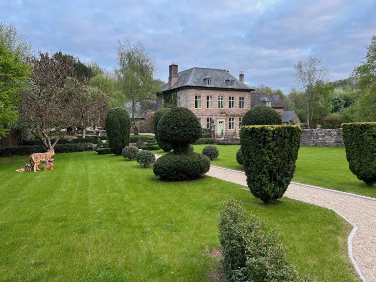 Topiary shapes on the lawn in front of the house on a spring evening, Tan House Newland